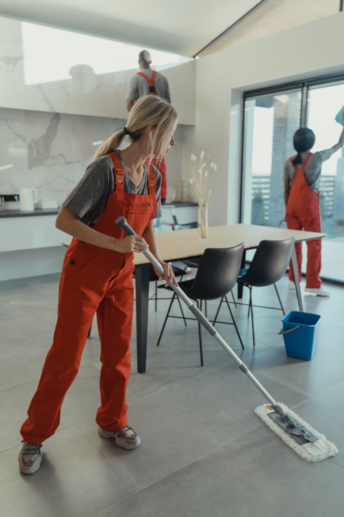 House cleaning cost Twin Cities varies by home size - professional cleaner mopping a modern home interior.